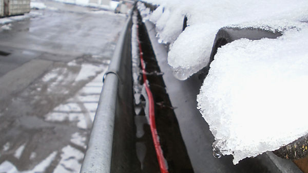 Elektrische verwarmingskabel in goot voorkomt sneeuw en ijs in de dakgoot