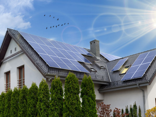 Ein Hausdach mit montierten Photovoltaikpaneele zur Stromerzeugung